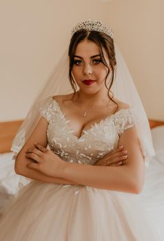 woman bride in white wedding dress with long veil and tiara on head