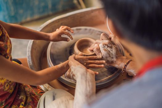 Father and son doing ceramic pot in pottery workshop.