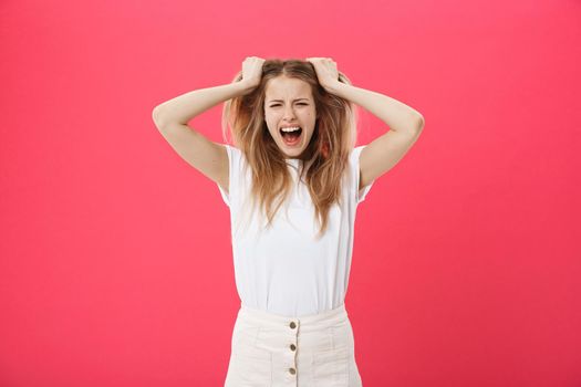 Young woman getting angry ,crazy and shouting isolated on a pink background.