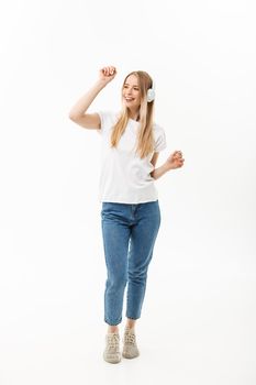Lifestyle Concept: Portrait of a cheerful happy girl student listening to music with headphones while dancing isolated over white background