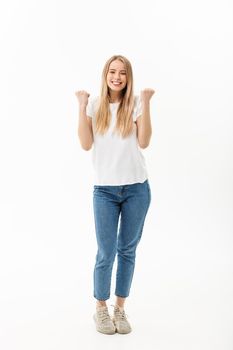 Full-length Portrait of a cheerful woman in white shirt and jean celebrating her success over white background
