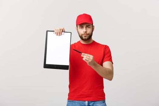 Delivery Concept: Portrait Young caucasian Handsome delivery man or courier showing a confirmation document form to sign. Isolated on Grey studio Background. Copy Space.