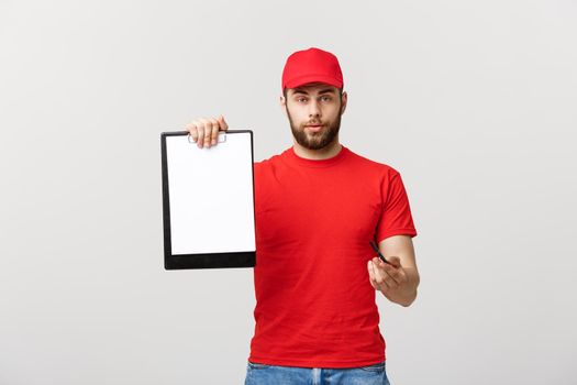 Delivery Concept: Portrait Young caucasian Handsome delivery man or courier showing a confirmation document form to sign. Isolated on Grey studio Background. Copy Space.