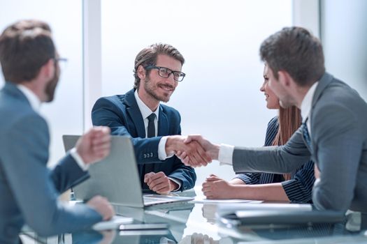 business partners reach out to each other for a handshake