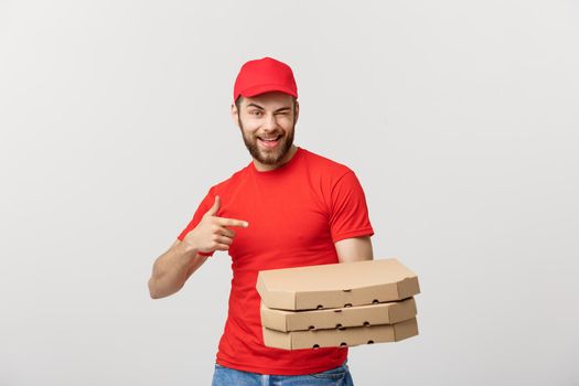 Delivery Concept: Handsome caucasian Pizza delivery man pointing finger. Isolated over grey background.