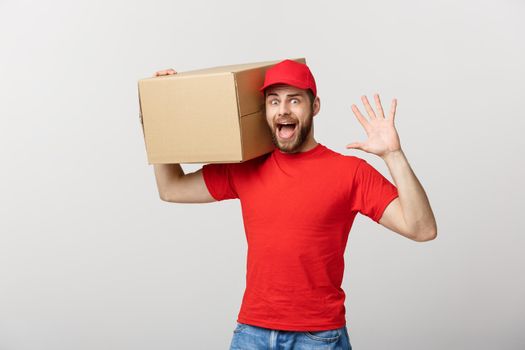 Delivery man doing surprise gesture holding cardboard boxes.