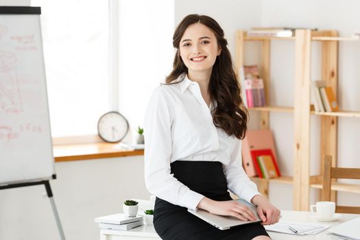 Young pretty business woman with notebook and document in the bright modern office indoors
