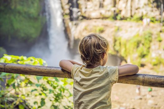 Boy traveler on a waterfall background. Ecotourism concept. Traveling with kids concept. What to do with children. Child friendly place