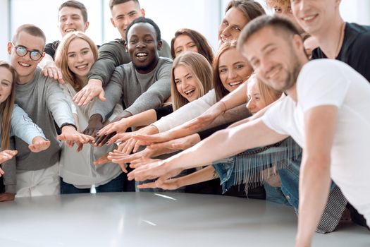 group of smiling young people joining their hands