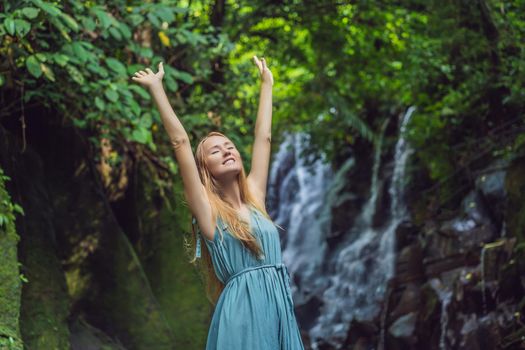 Woman traveler on a waterfall background. Ecotourism concept