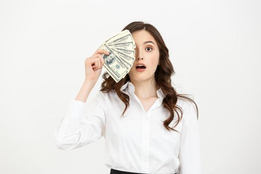 Portrait shocked young business woman standing and holding money isolated over white background.