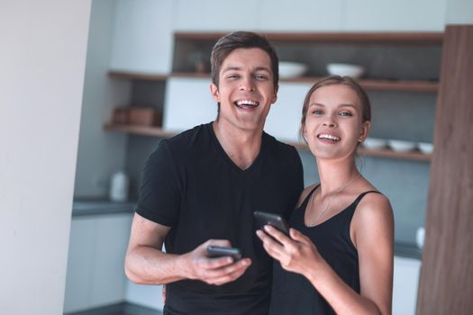 cheerful young couple reading email on smartphone.