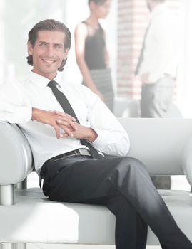 smiling businessman sitting in office chair