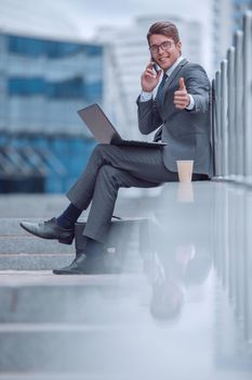 young businessman with modern devices showing gesture OK