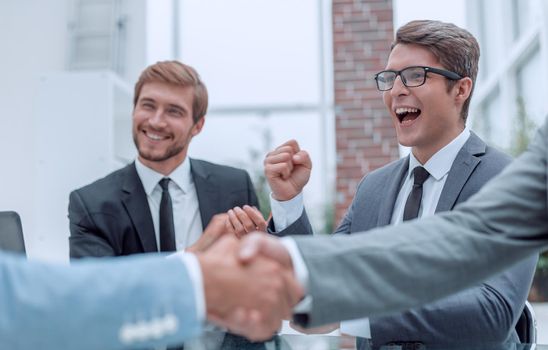 handshake of business people on a blurred office background.
