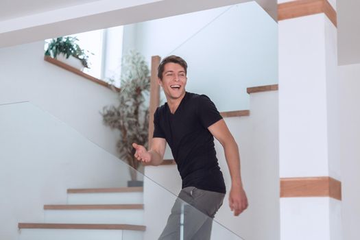 happy young man standing on the stairs in his new apartment.