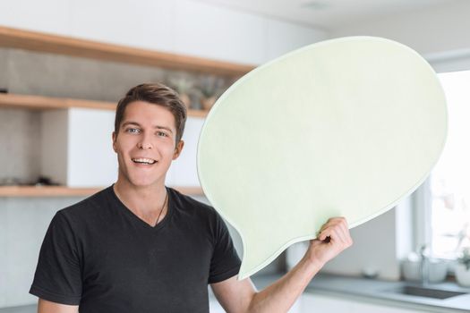 smiling man with balloon for text standing in new kitchen