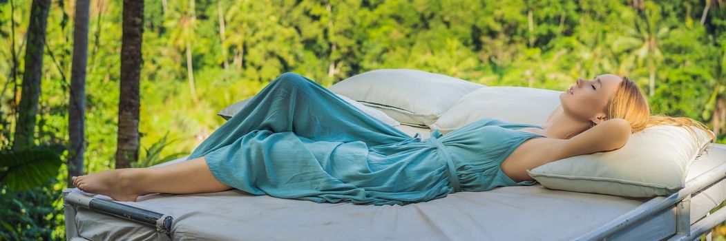 Young woman in bed over the jungle. Intimacy with nature BANNER, LONG FORMAT