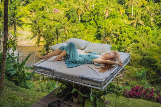 Young woman in bed over the jungle. Intimacy with nature