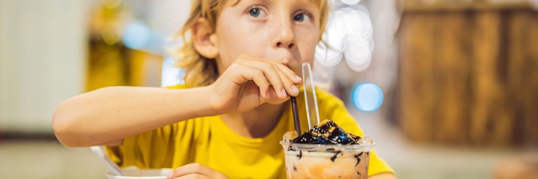 Boy eating ice cream in a cafe BANNER, LONG FORMAT