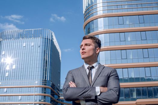 serious business man standing near a tall office building.