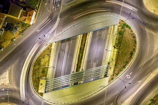 Circle junction traffic road with car light movement aerial view from a drone.