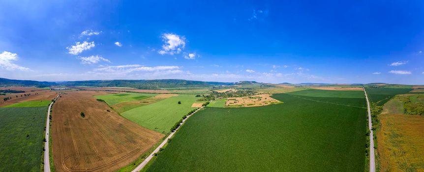 vast aerial panorama view from drone to the countryside roads and fields