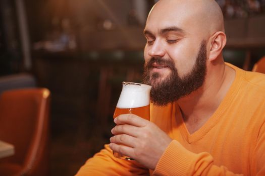 Bearded man enjoying drinking beer at the pub