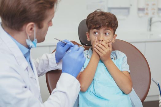 Charming young boy getting teeth checkup at the dentist