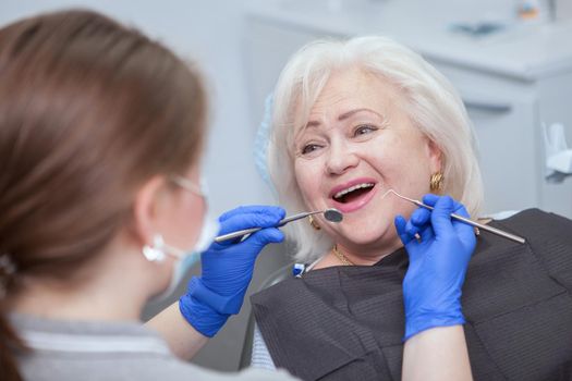 Close up of a cheerful elderly woman having dental examination by her dentist