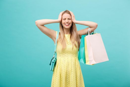 Shoping and Sale Concept: beautiful unhappy young woman in yellow elegant dress with shopping bag.