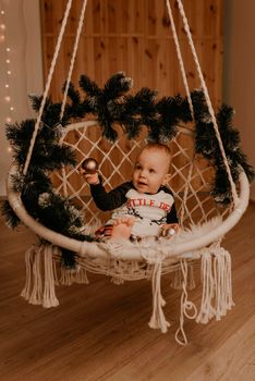 little baby girl sitting in chair and playing. Christmas morning. New Year's interior. Valentine's Day celebration
