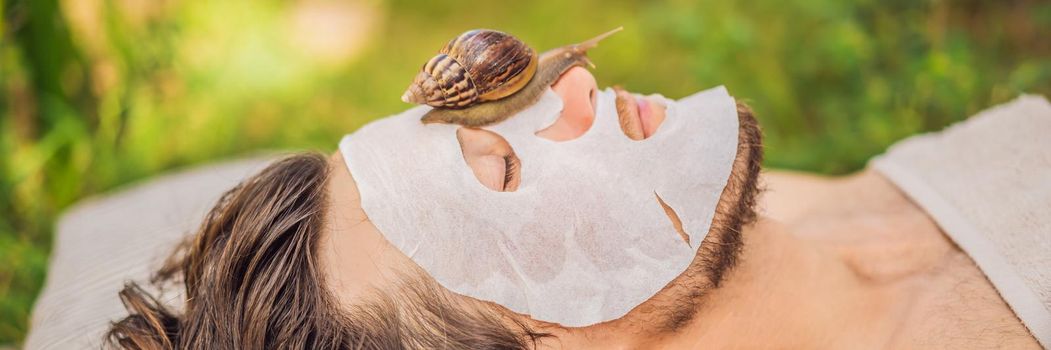 Young man makes a face mask with snail mucus. Snail crawling on a face mask. SPA for man, SPA for all BANNER, LONG FORMAT