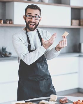 attractive man showing a piece of delicious cheese