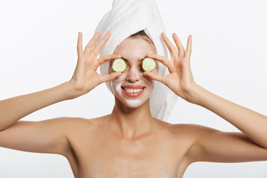 Beauty Portrait Of Smiling Woman With Towel On Head And Slice Of Cucumber In Hand Isolated On White Background.