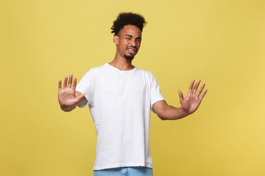 Portrait furious angry annoyed displeased young man raising hands up to say no stop right there isolated orange background. Negative human emotion, facial expression, sign, symbol, body language.