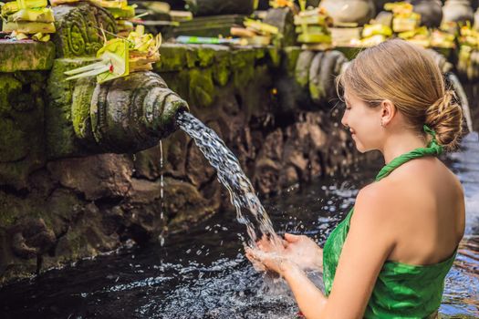 Woman in holy spring water temple in bali. The temple compound consists of a petirtaan or bathing structure, famous for its holy spring water