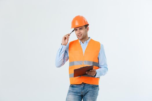 Disappointed handsome engineer wearing orange vest and jeans with helmet, isolated on white background