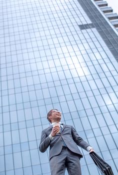 modern business man standing near a tall office building