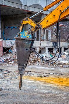 Arm of excavator with hydraulic breaker hammer for the destruction of concrete and hard rock at the construction site. Demolition equipment