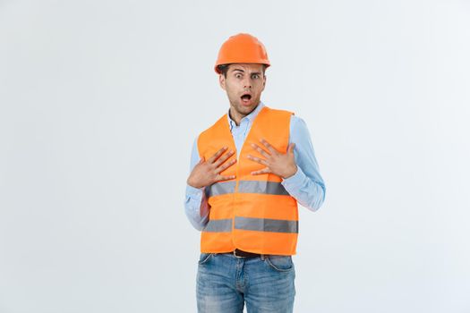 Young engineer opens his mouth shocked looking away, isolated on a white background.
