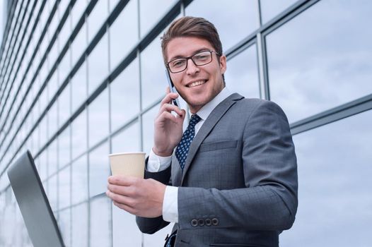 corporate young man sitting next to an office building