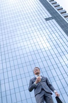 modern business man standing near a tall office building