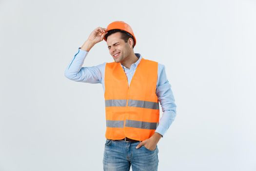 Handsome young engineer man over white background wearing safety helmet with serious face and hand shocked with shame for mistake, expression of fear, scared in silence, secret concept