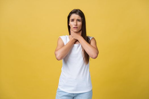 Sick woman suffering from sore throat isolated over yellow background.