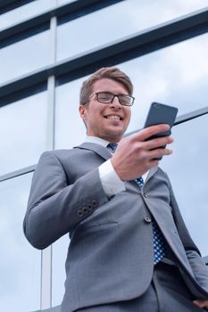 smiling business man reading SMS on his smartphone