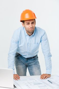 Young man wearing architect outfit and helmet with angry face, negative dislike emotion. Angry and rejection concept