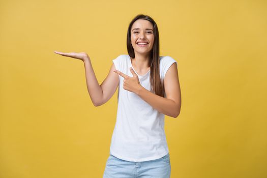 Portrait of a cheerful girl holding copyspace on the palm isolated on a yellow background