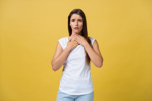 Sick woman suffering from sore throat isolated over yellow background.