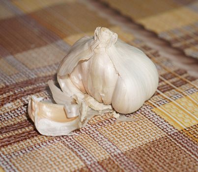 garlic in the husk on the background of the tablecloth